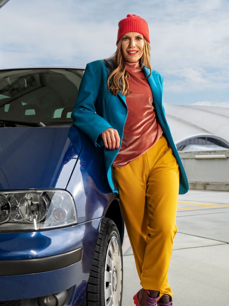 Kobieta opiera się o samochód VW Sharan 1 – starsze minivany