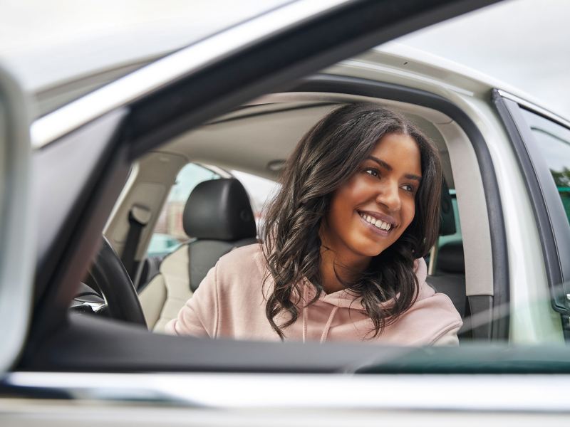 Close-up of woman getting out of VW Passat