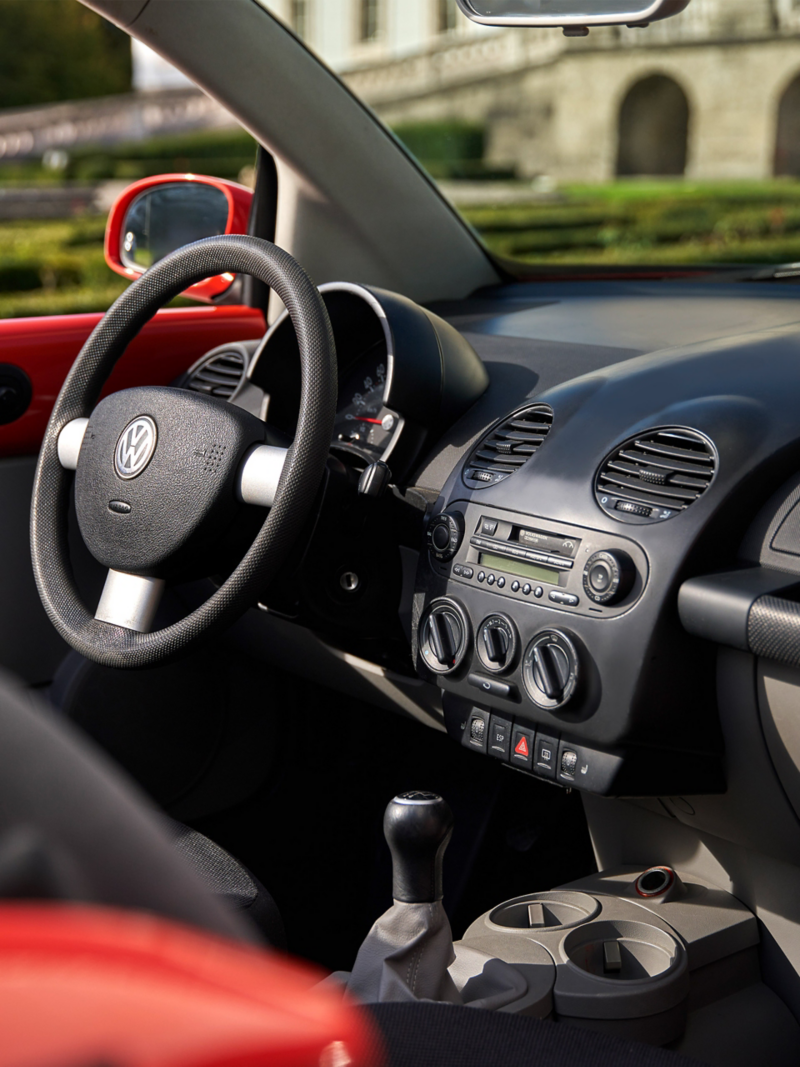 Interior de un Volkswagen New Beetle con foco en el cockpit