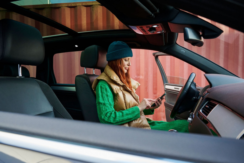 A woman sends a text message to the VW Roadside Assistance – emergency service