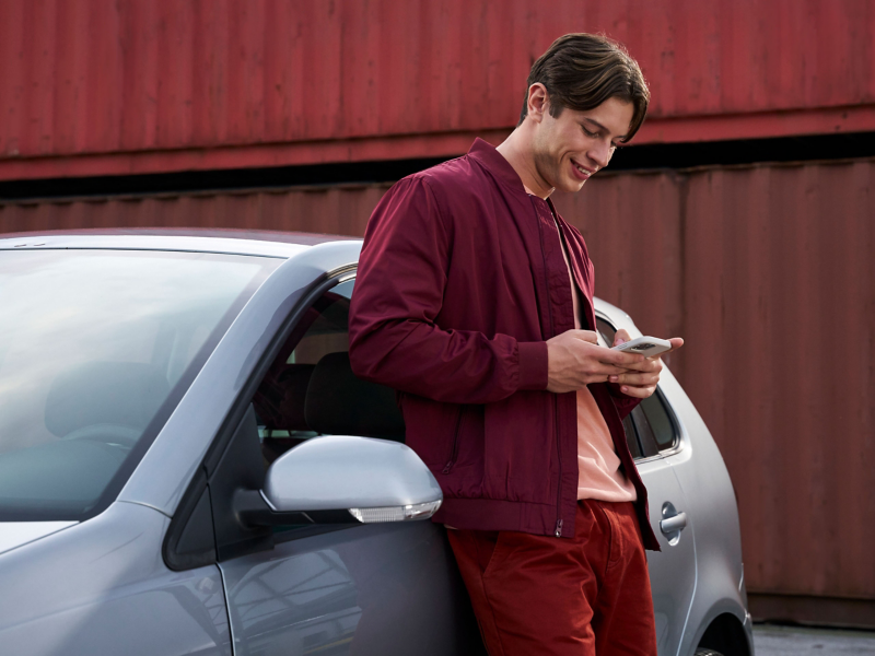 Man leaning against his VW small car previous model