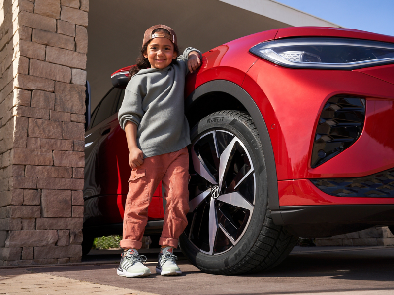 Девочка прислонилась к VW ID.5 GTX, в фокусе шина