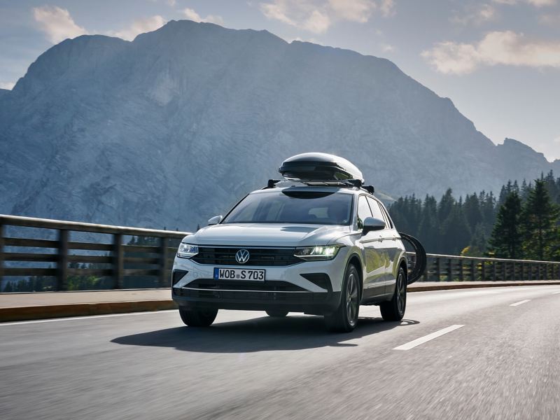 VW Tiguan 2 with VW Accessories roof box drives on mountain road