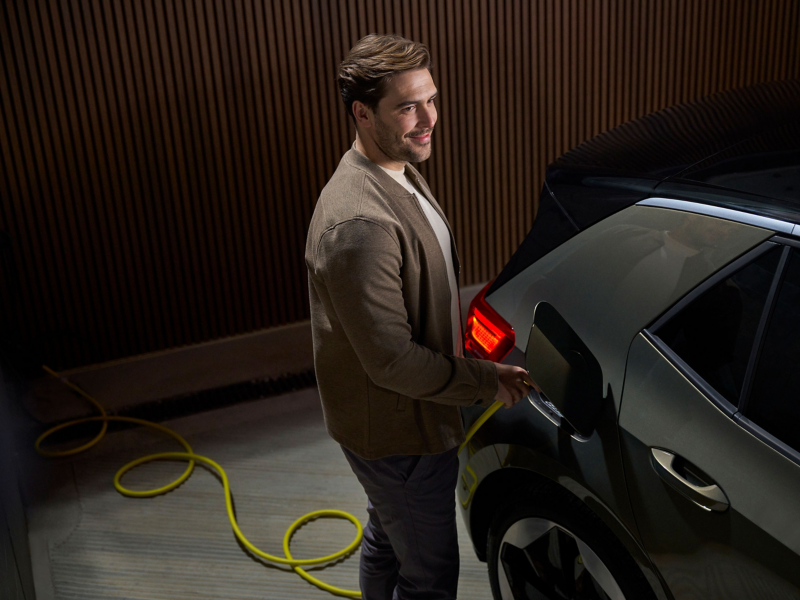Άντρας φορτίζει ένα αυτοκίνητο VW ID. με καλώδιο φόρτισης