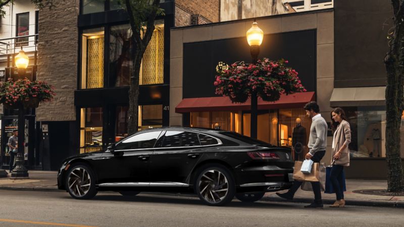 Arteon on the street with man and woman approaching trunk 