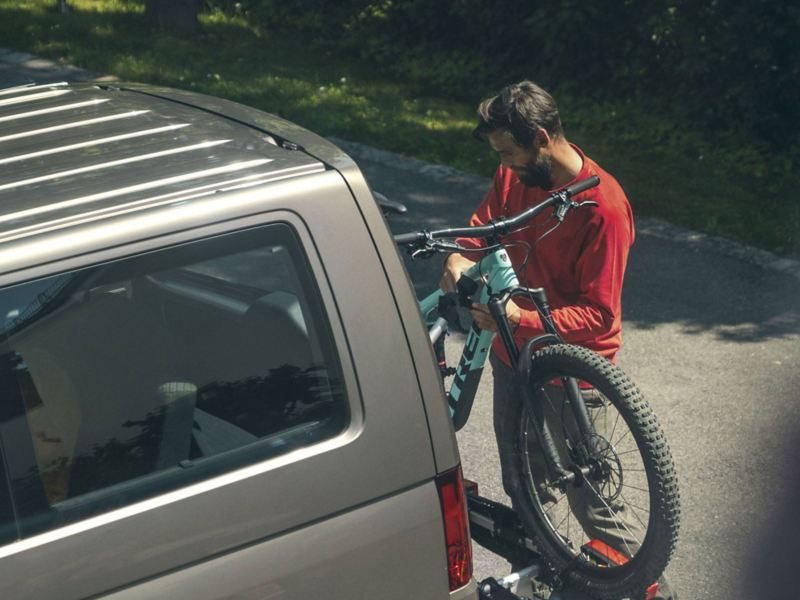 Un ragazzo carica la propria bici sul portabici installato su Multivan Volkswagen