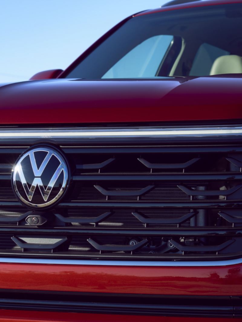 A close-up photo of the red 2024 Volkswagen Atlas featuring radiator grilles and front headlights