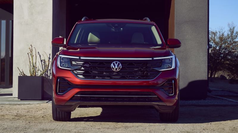 The red 2024 Volkswagen Atlas parked near a house during the day