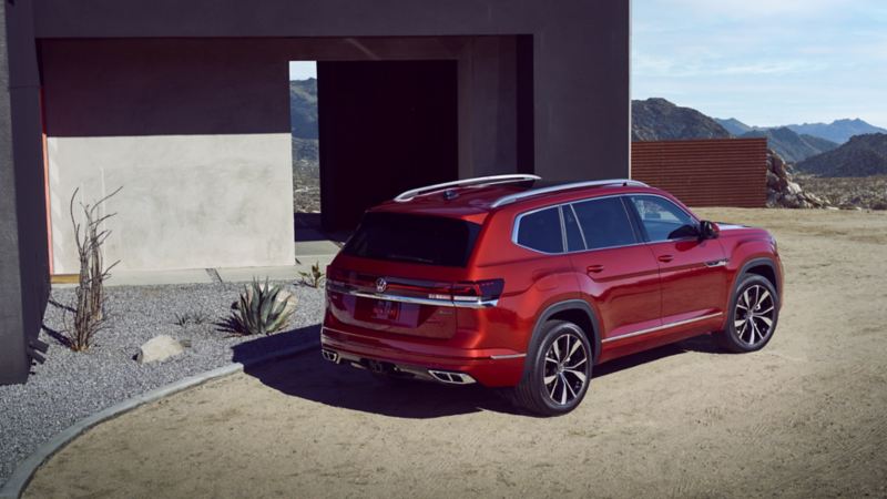 The red 2024 Volkswagen Atlas with panoramic sunroof parked near the house