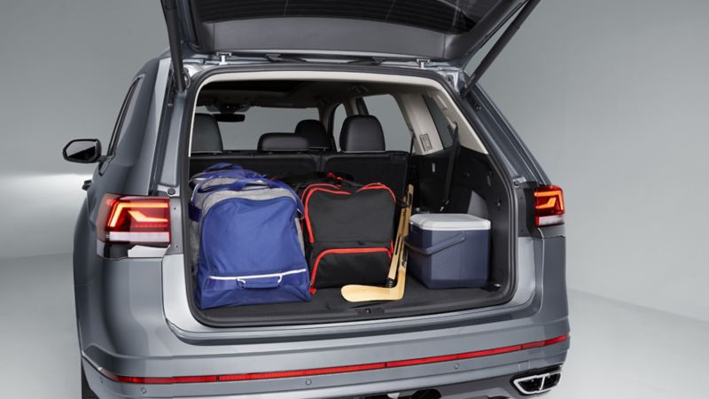 The cargo space of the 2023 Volkswagen Atlas full of bags, hockey sticks, and a cooler 