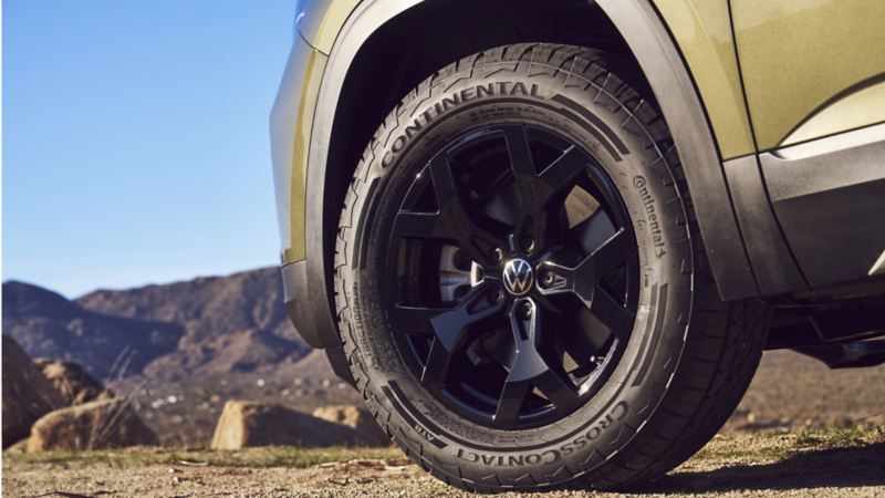 Un gros plan des roues (noires) Magnum en alliage de 18 po et des robustes pneus tout-terrain de l’Atlas 2024 de Volkswagen