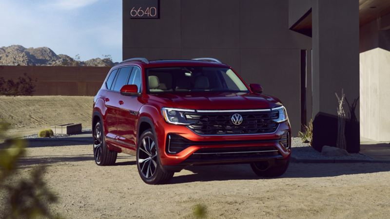 The red 2024 Volkswagen Atlas parked near a house