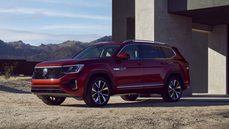 The red 2024 Volkswagen Atlas parked near a modern house