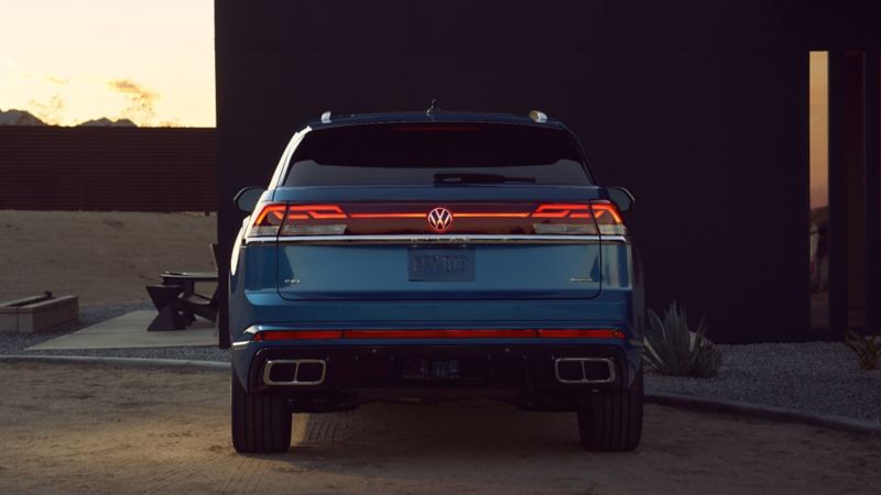 Vue arrière d’un Atlas Cross Sport 2024 de Volkswagen stationné près d’une maison moderne
