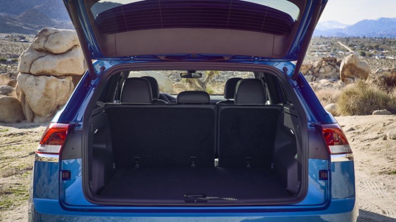 Coffre ouvert d’un Atlas Cross Sport 2024 de Volkswagen bleu avec 2 197 litres d’espace de chargement