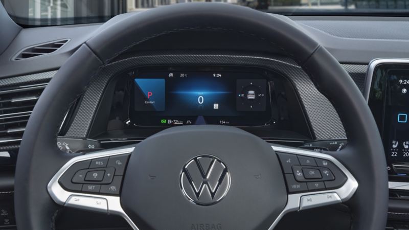 The interior of the 2024 Volkswagen Atlas Cross Sport featuring a steering wheel, dashboard, and front seats