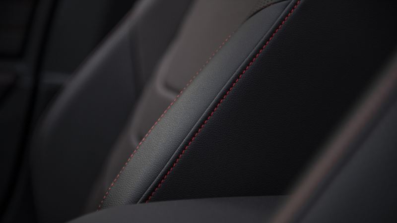 Un gros plan du siège d’auto d’une Jetta GLI 2024. Le siège en cuir est de couleur noire avec des surpiqûres rouges.