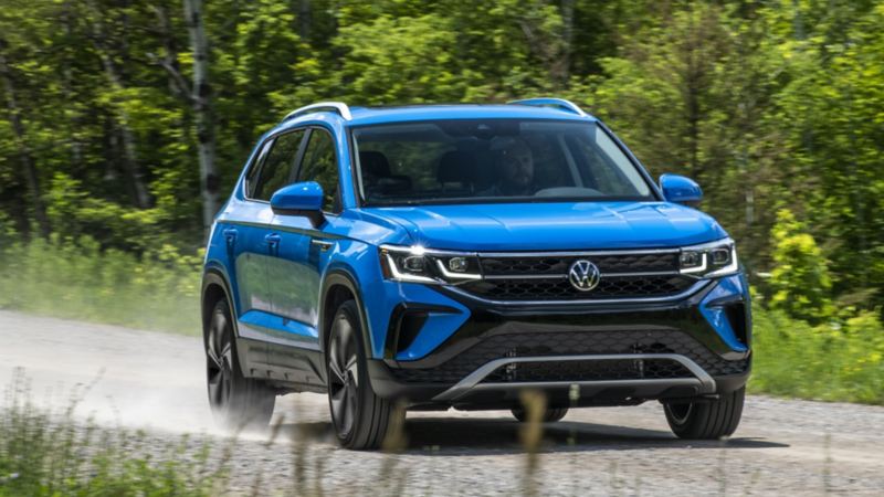 The blue 2024 Volkswagen Taos driving on the road