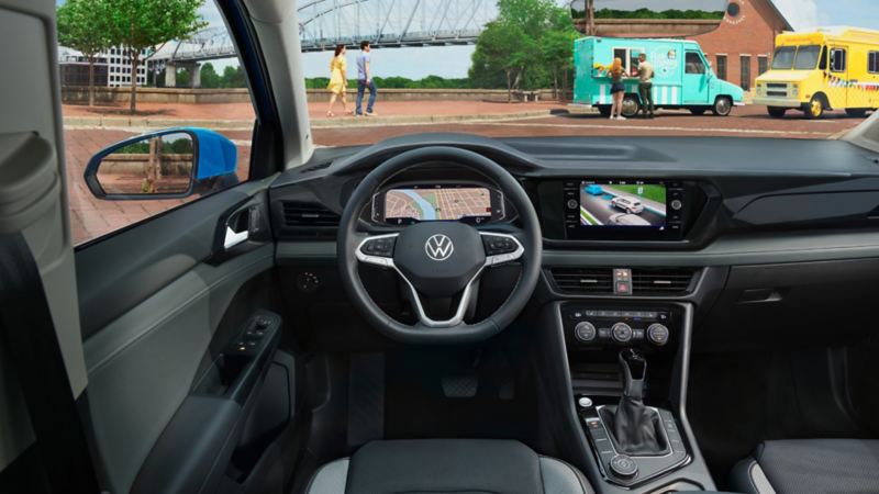 L’intérieur d’un Taos 2024 de Volkswagen montrant le tableau de bord, les sièges avant et le volant