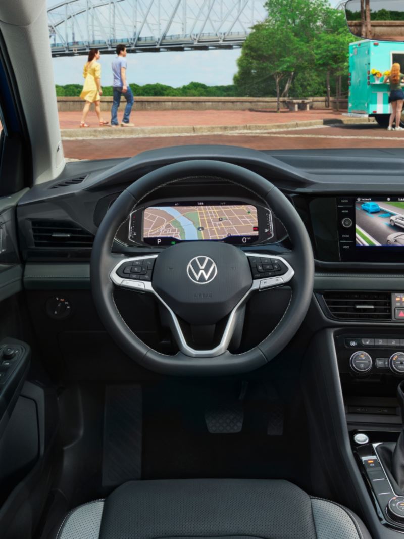 The interior of the 2024 Volkswagen Taos featuring dashboard, front seats and steering wheel.