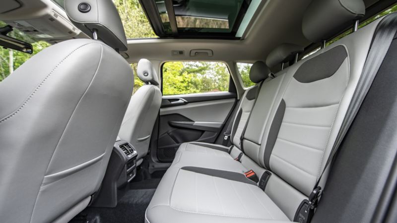 The interior of the 2024 Volkswagen Taos featuring back seats, windows and a sunroof.