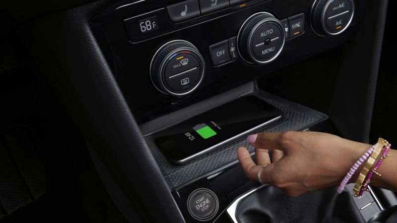 A close-up photo of the mobile phone charging on the wireless charging pod of the 2024 Volkswagen Taos