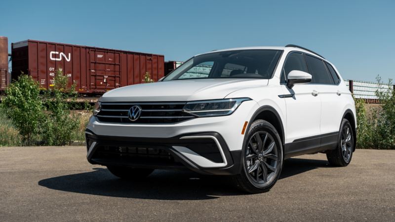 The white 2024 Volkswagen Tiguan parked near a railway road