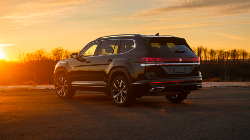 A 2025 Atlas, bathed in the warm hues of sunset, showcases its sleek design and reflective surfaces, with the rear headlight catching the fading light.