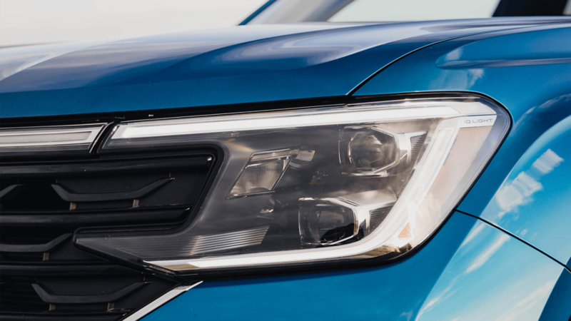 A close-up view of the sleek headlight of a blue Atlas Cross Sport.