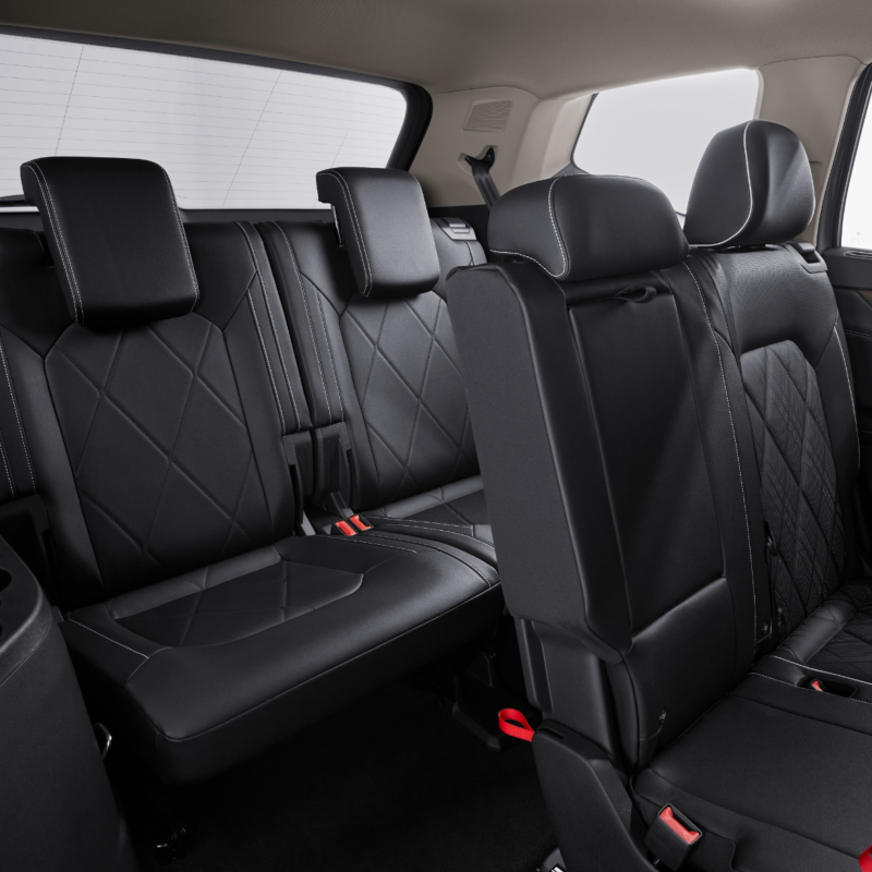 A luxurious rear view of the Atlas 2025 SUV interior, featuring spacious black leather seats with diamond stitching, offering easy access to the third row.
