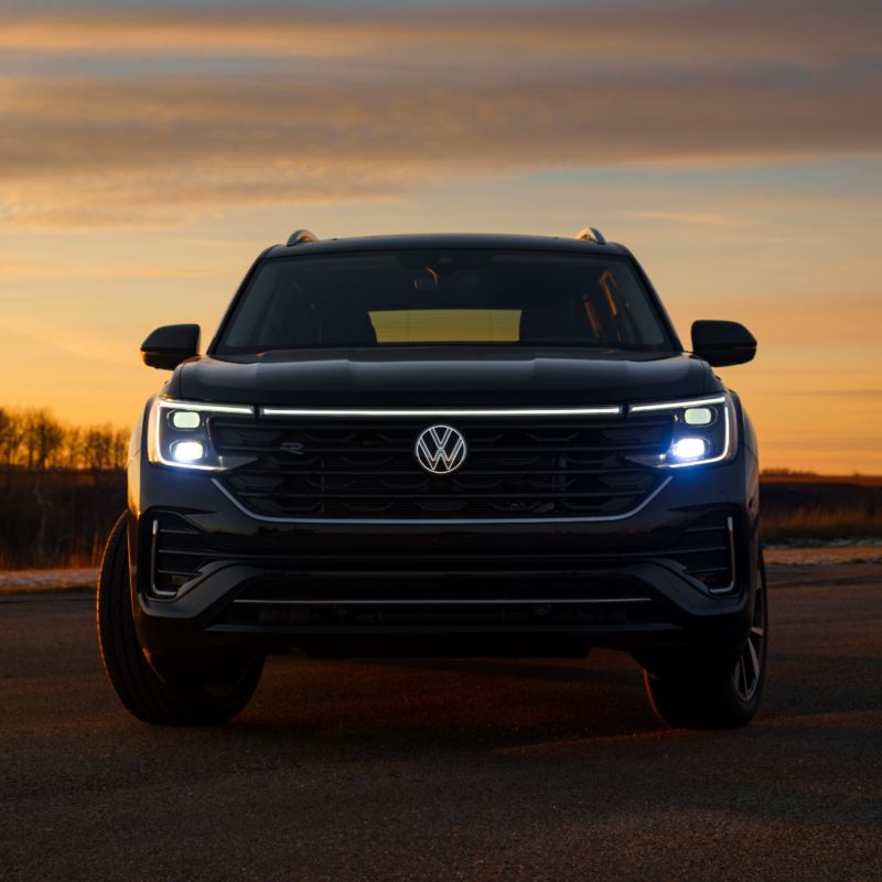 Front view of black Volkswagen Atlas 2025 against a stunning sunset backdrop.