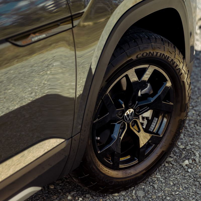 A close-up of a 2025 Atlas wheel and tire, designed to conquer any terrain with its all-terrain tread pattern.