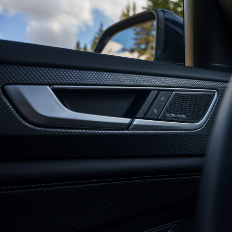A close-up view of a Harman Kardon Premium Audio speaker system seamlessly integrated into the door panel of an Atlas Cross Sport 2025. 