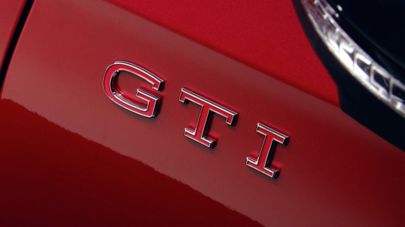 Gros plan sur le logo GTI d'une Volkswagen Golf rouge.