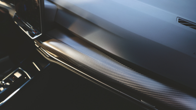 Close-up of genuine carbon fiber dashboard and door trims in the Volkswagen Golf R's interior.