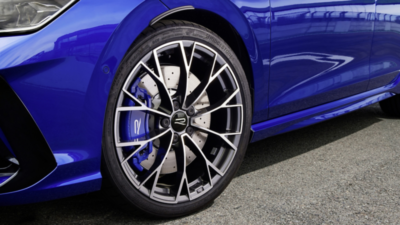 Close-up of the alloy wheel and brake caliper on a blue Volkswagen Golf R.