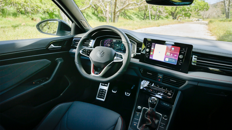 Interior view of the 2025 Volkswagen Jetta GLI showcasing its new interior design with a focus on the dashboard and steering wheel.