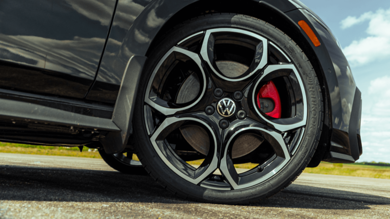 Close-up of 2026 Volkswagen Golf GTI alloy wheel with red brake caliper. 