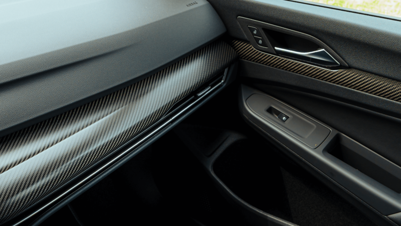 Gros plan sur les garnitures de tableau de bord et de portières en véritable fibre de carbone à l'intérieur de la Volkswagen Golf R.