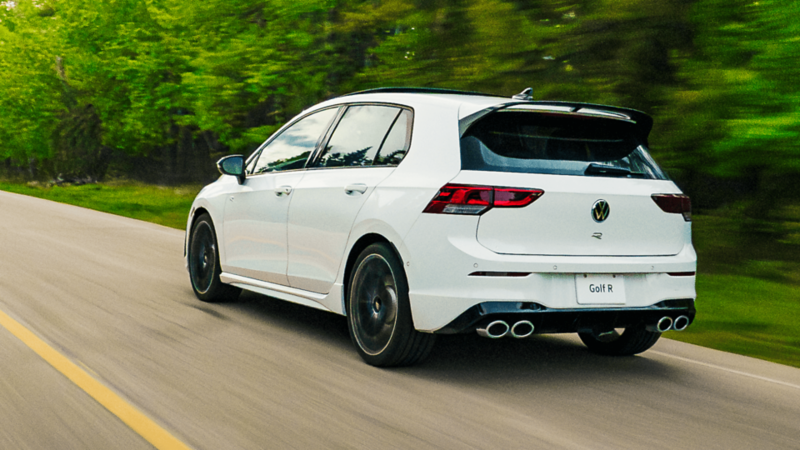 Une Volkswagen Golf R bleue avec un aileron arrière pour une meilleure déportance et une meilleure tenue de route, photographiée sur un circuit de course.