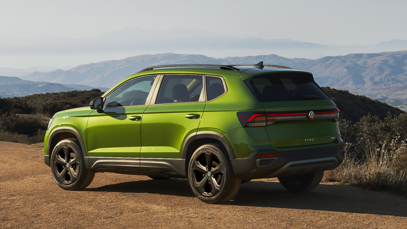 Arrière d'un Volkswagen Taos 2025 vert au coucher du soleil.