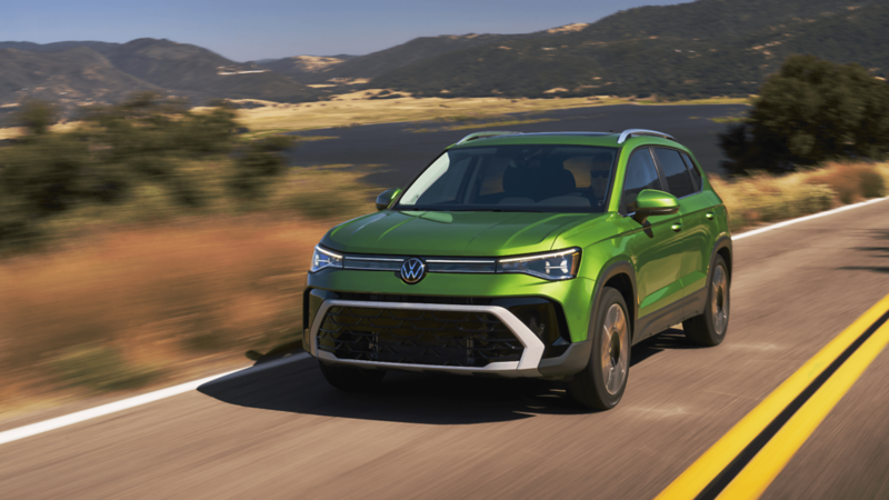 2026 Volkswagen Taos in motion with rolling hills and mountains in the backdrop