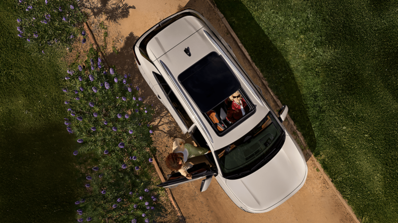 Overhead view of the 2026 Volkswagen Tiguan SUV with open panoramic sunroof and passengers inside.
