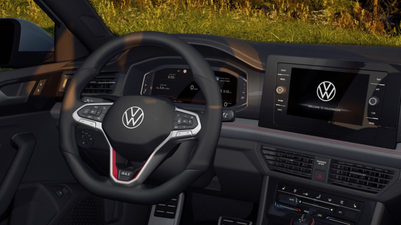 Driver’s cockpit of the Jetta GLI with digital cluster, sport steering wheel, and infotainment screen. 