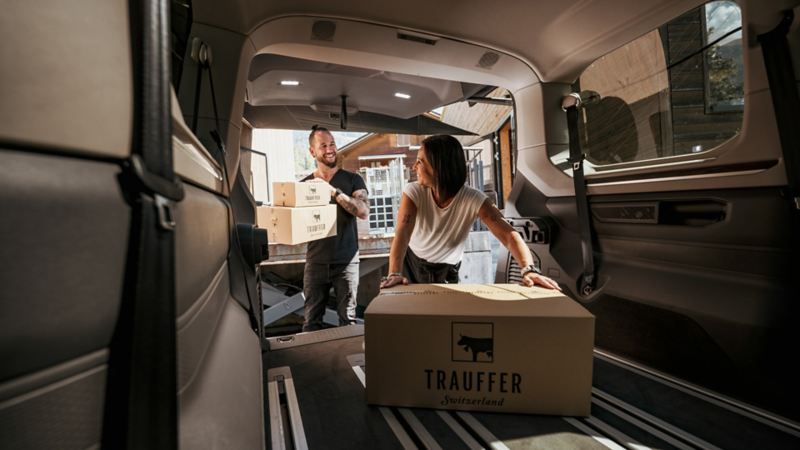 Marc et Brigitte Trauffer rangent des caisses dans leur VW Multivan eHybrid