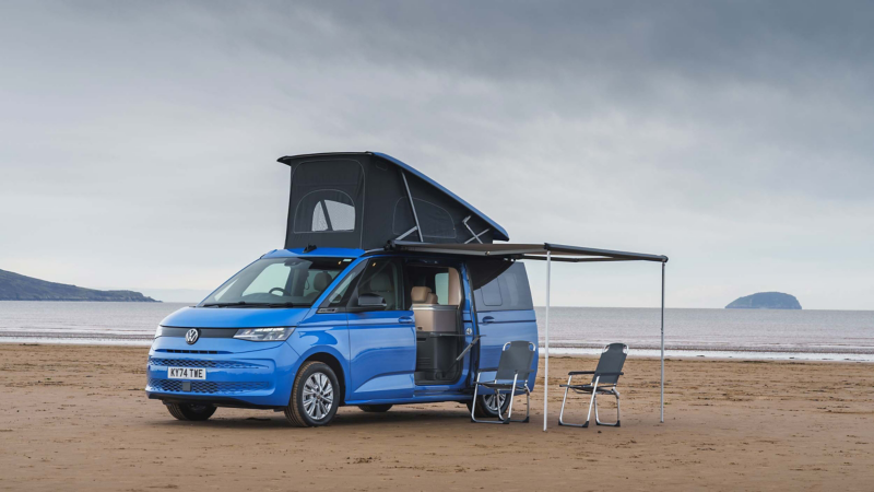 Photo of a California parked on a beach with awning and roof module deployed. 