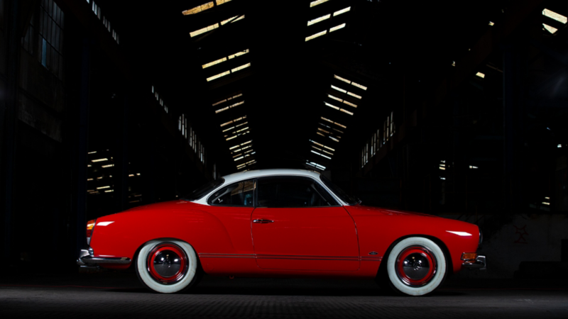 Andre Martys roter Karman Ghia von der Seite in einer Fabrikhalle.