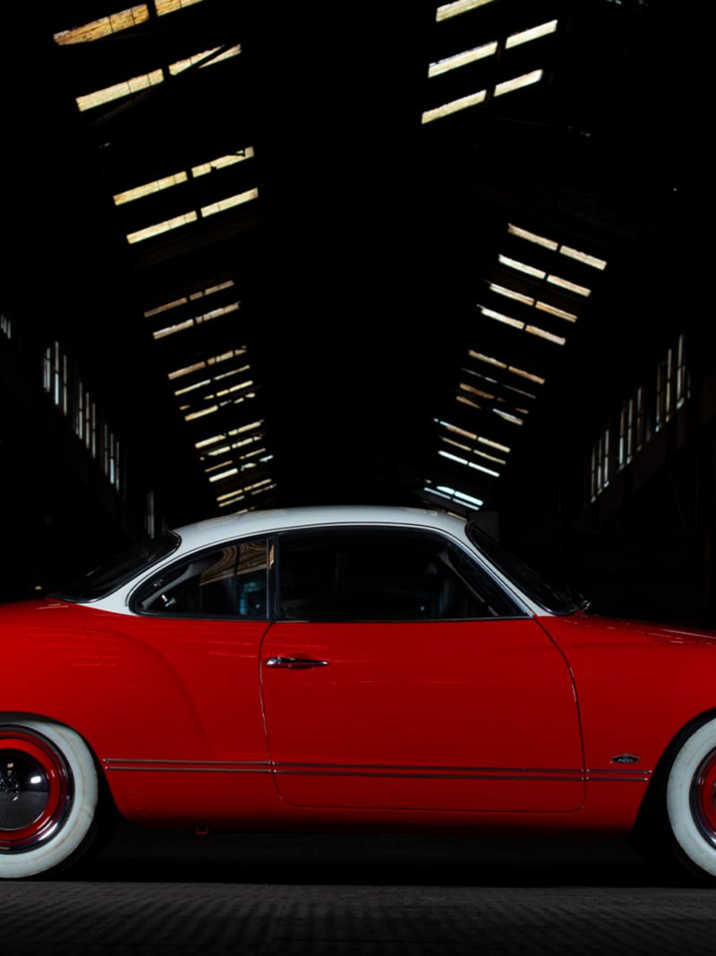 La Karman Ghia rossa di Andre Marty di lato su un pavimento della fabbrica.