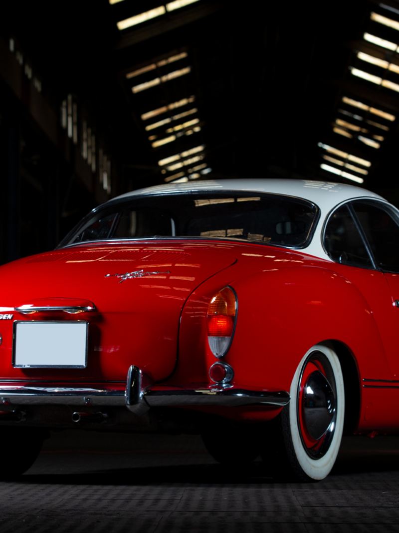 La Karman Ghia rouge d'Andre Marty vue de l'arrière dans un hall d'usine.