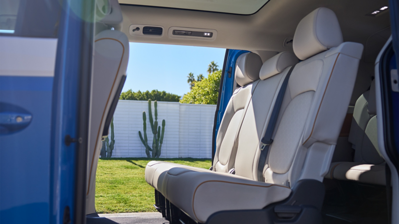 The Volkswagen ID. Buzz 2025 interior with spacious seating, panoramic sunroof, and open sliding doors featuring the "Easy Open" virtual pedal. 